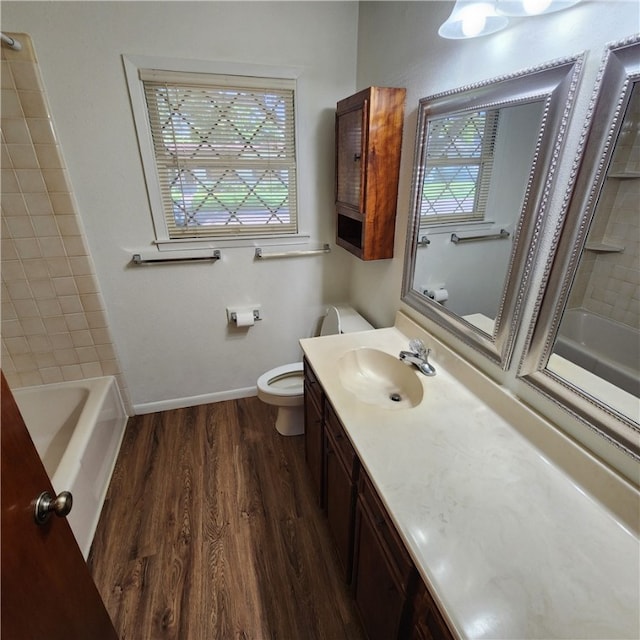 full bathroom with baseboards, toilet, wood finished floors,  shower combination, and vanity