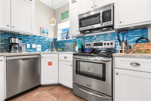 kitchen featuring light tile patterned flooring, crown molding, stainless steel appliances, white cabinetry, and sink