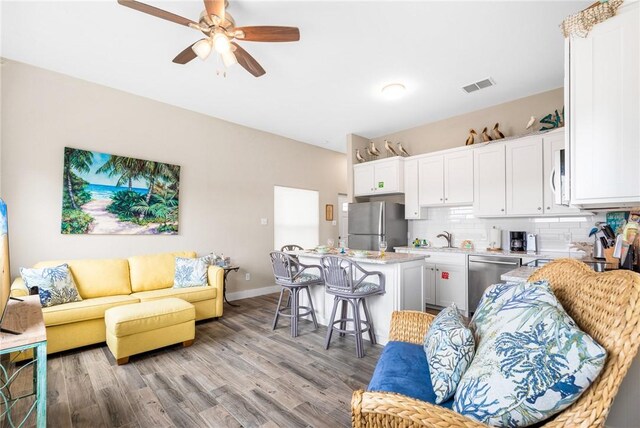 664 Kara Prt, Aransas, TX 78373 - living room with a ceiling fan, light wood-type flooring, and baseboards