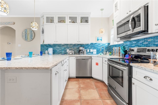 kitchen featuring white cabinetry, appliances with stainless steel finishes, ornamental molding, backsplash, and pendant lighting