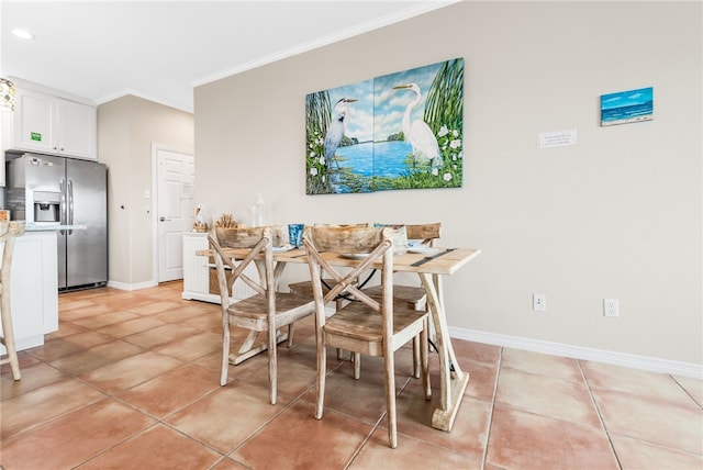 tiled dining room featuring breakfast area and ornamental molding