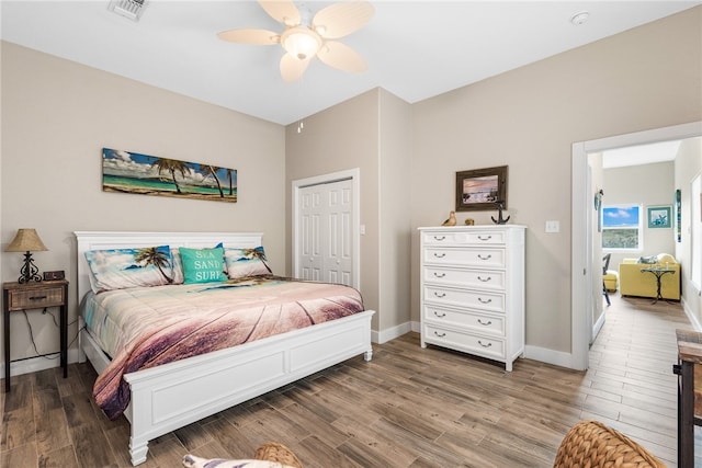 bedroom featuring hardwood / wood-style flooring, ceiling fan, and a closet