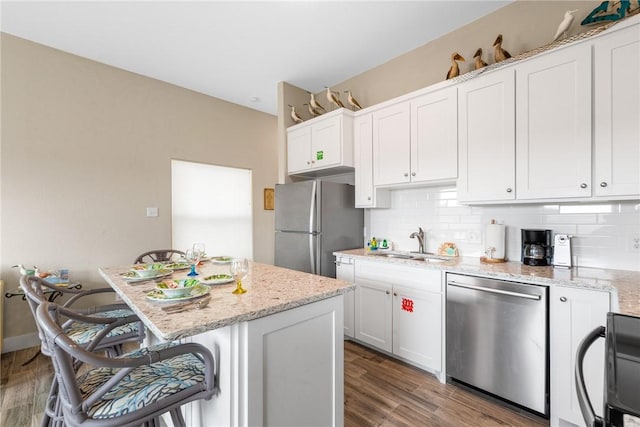664 Kara Prt, Aransas, TX 78373 - kitchen with appliances with stainless steel finishes, a sink, a kitchen breakfast bar, and decorative backsplash