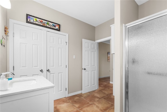 bathroom with walk in shower, vanity, and tile patterned floors