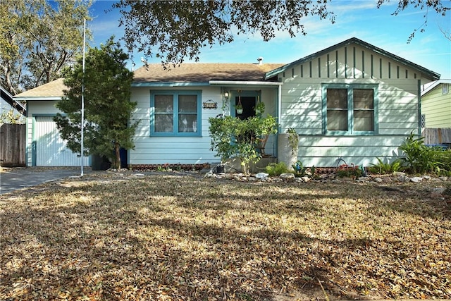 single story home with board and batten siding, a front yard, and fence