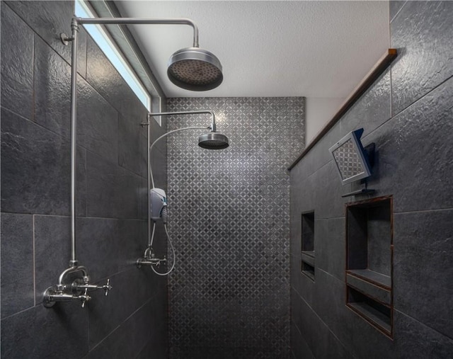 bathroom featuring a textured ceiling and a tile shower