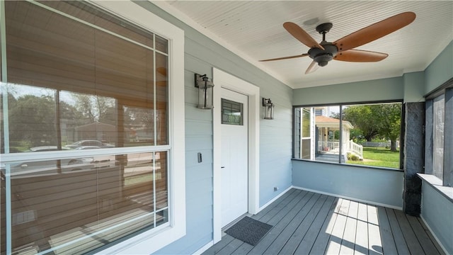unfurnished sunroom with ceiling fan