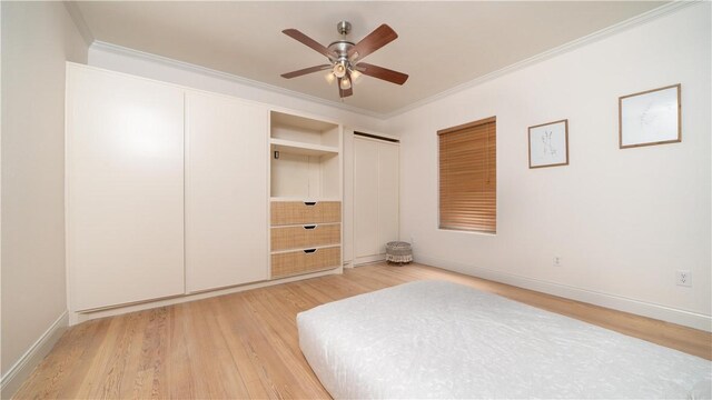 unfurnished bedroom featuring light wood-style flooring, two closets, baseboards, ornamental molding, and ceiling fan