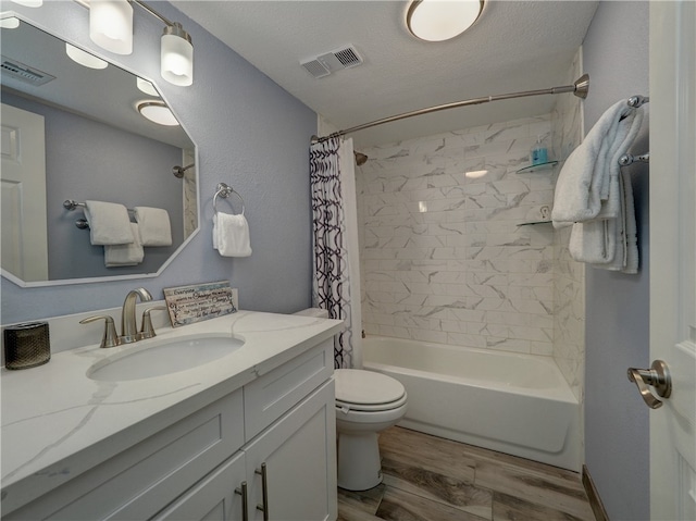 full bathroom featuring vanity, a textured ceiling, shower / tub combo, hardwood / wood-style floors, and toilet