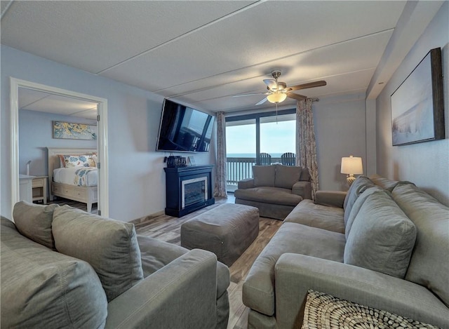 6109 State Highway 361 Unit 1101, Port Aransas, TX 78373 - living room with ceiling fan, wood finished floors, a fireplace, and baseboards