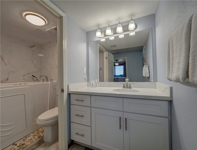 bathroom with vanity, a textured ceiling, a tub, hardwood / wood-style flooring, and toilet