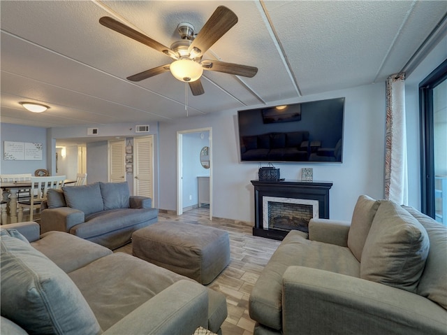 living room with ceiling fan and a textured ceiling