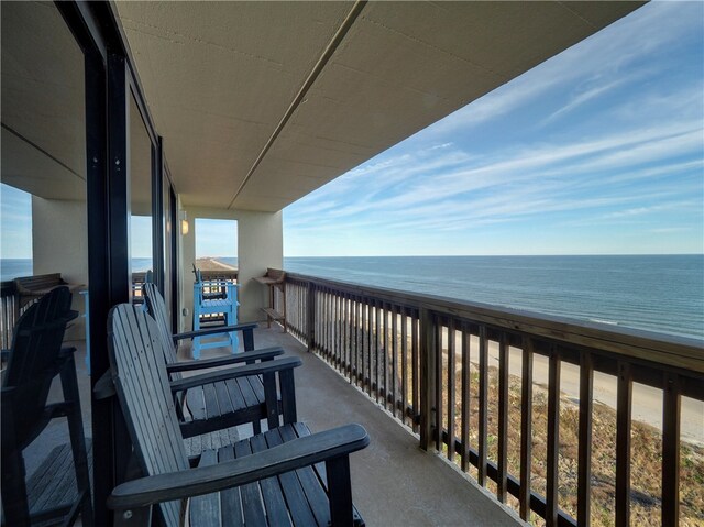 balcony featuring a beach view and a water view