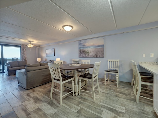 dining room featuring ceiling fan and a textured ceiling