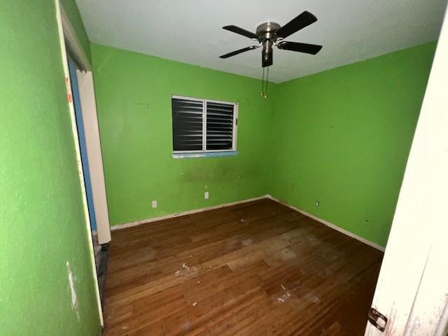 667 Lisa Ann Dr, Aransas Pass, TX 78336 - unfurnished room featuring baseboards, wood finished floors, and a ceiling fan