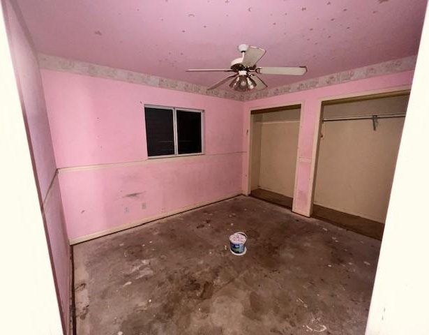 667 Lisa Ann Dr, Aransas Pass, TX 78336 - unfurnished bedroom with unfinished concrete floors, multiple closets, and ceiling fan