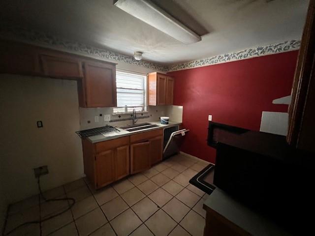 667 Lisa Ann Dr, Aransas Pass, TX 78336 - kitchen with dishwasher, light tile patterned floors, a sink, and light countertops