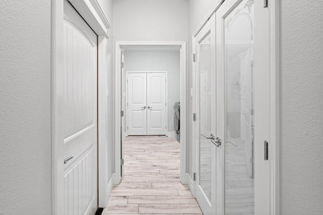 3726 Amanda Ln, Robstown, TX 78380 - hall with light wood-type flooring, a textured wall, and washer / dryer