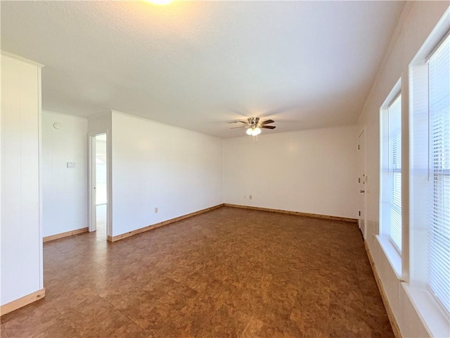 empty room featuring a ceiling fan, baseboards, and tile patterned floors