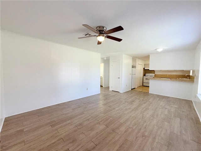 unfurnished living room featuring light wood-style floors and a ceiling fan