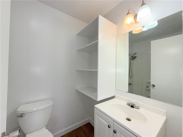 bathroom with baseboards, a shower, toilet, an inviting chandelier, and vanity