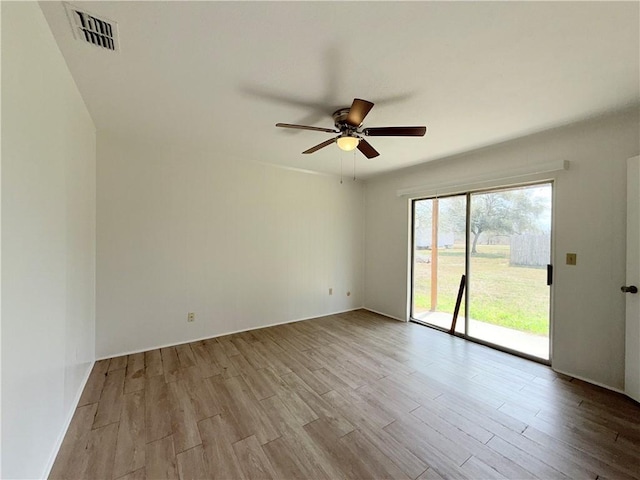 spare room with ceiling fan, visible vents, and wood finished floors