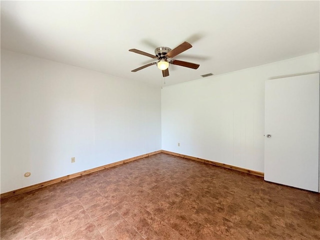 empty room featuring visible vents, ceiling fan, and baseboards