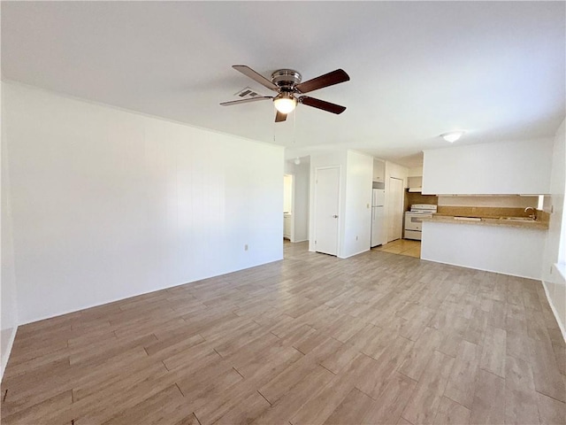 unfurnished living room featuring a ceiling fan and light wood-type flooring