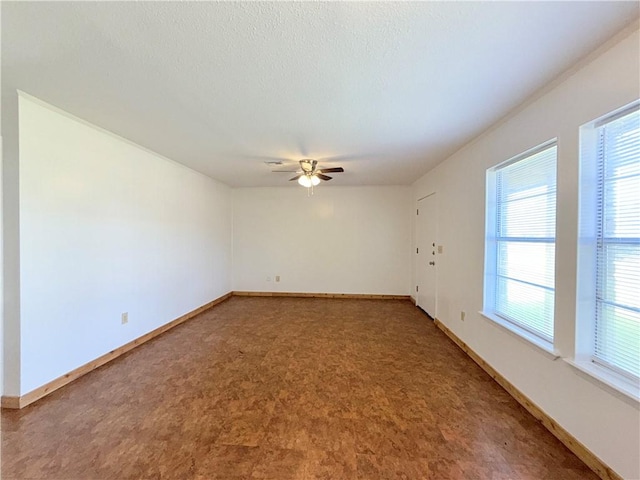 spare room featuring ceiling fan, baseboards, a textured ceiling, and tile patterned floors