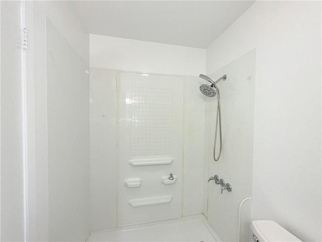 full bathroom featuring walk in shower and toilet