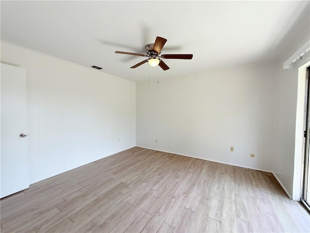 unfurnished room with light wood finished floors, visible vents, and a ceiling fan