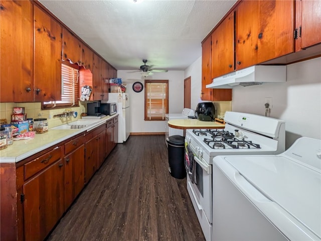 kitchen with sink, ceiling fan, washer / clothes dryer, white appliances, and dark wood-type flooring