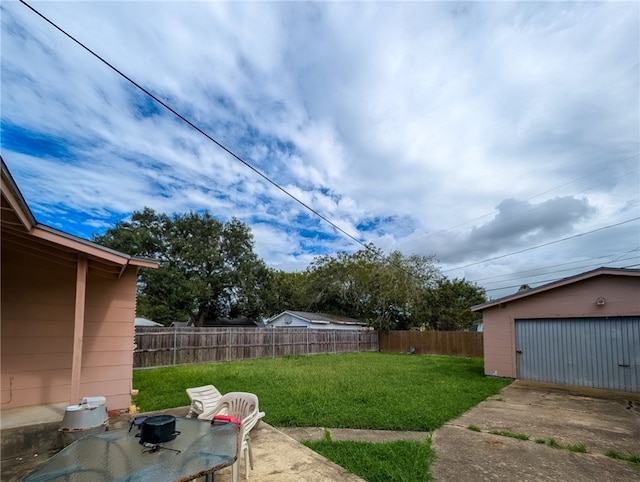 view of yard with a garage and an outbuilding