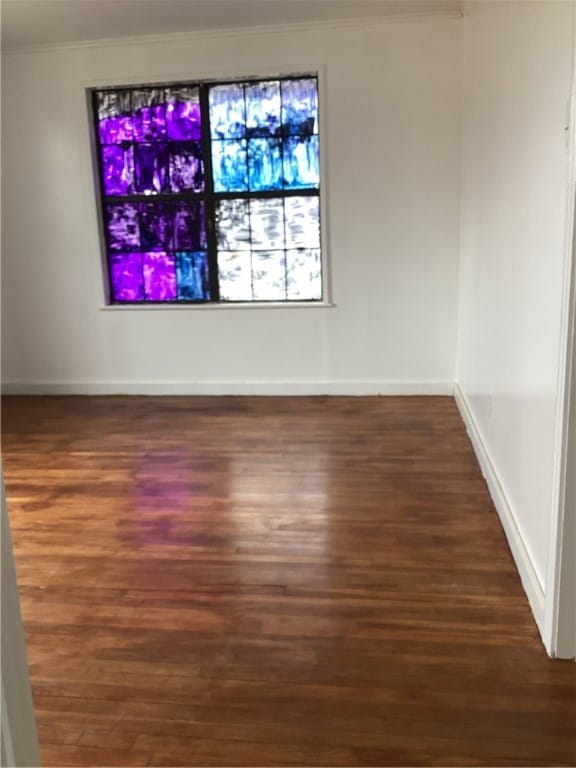 empty room with crown molding and dark hardwood / wood-style flooring