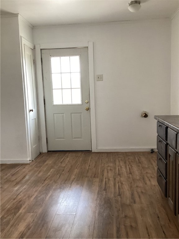 doorway to outside featuring dark hardwood / wood-style floors and crown molding