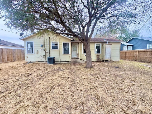 rear view of property with cooling unit and fence