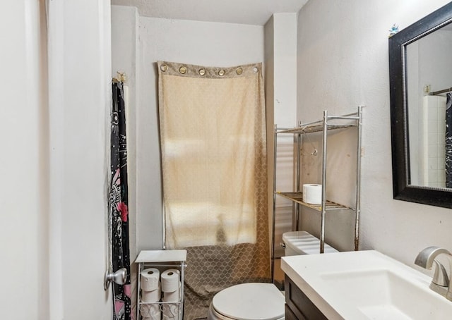 full bath featuring a shower, vanity, and toilet