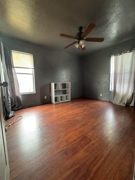 empty room featuring ceiling fan, a textured ceiling, and wood finished floors