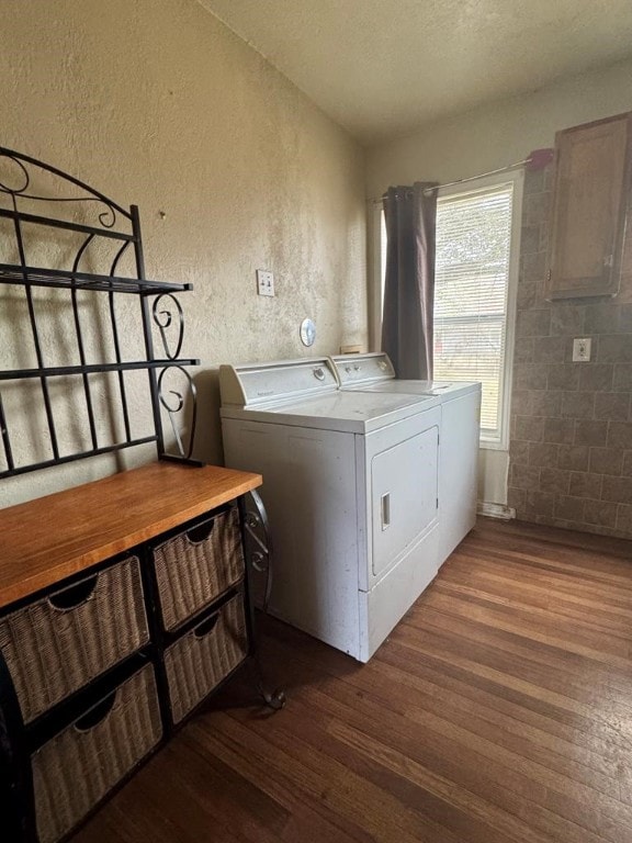 clothes washing area featuring dark wood-style floors, separate washer and dryer, a textured ceiling, and a textured wall