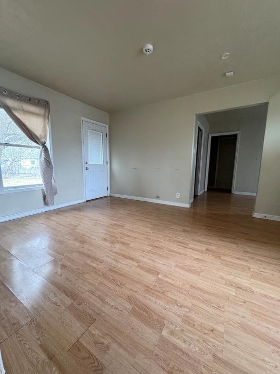 unfurnished room with light wood finished floors and baseboards