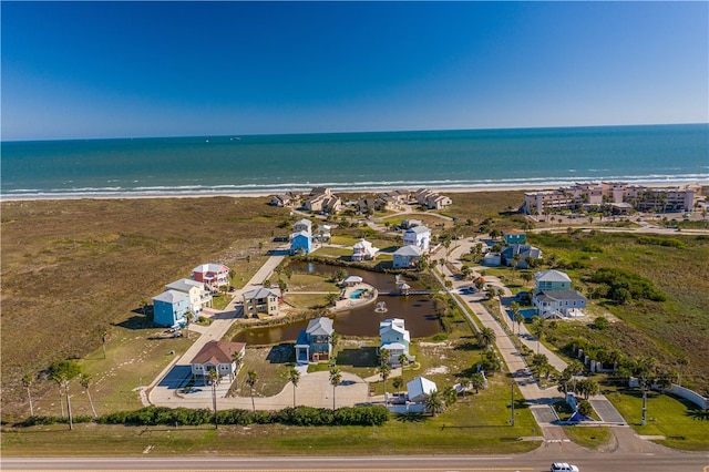 drone / aerial view featuring a beach view and a water view