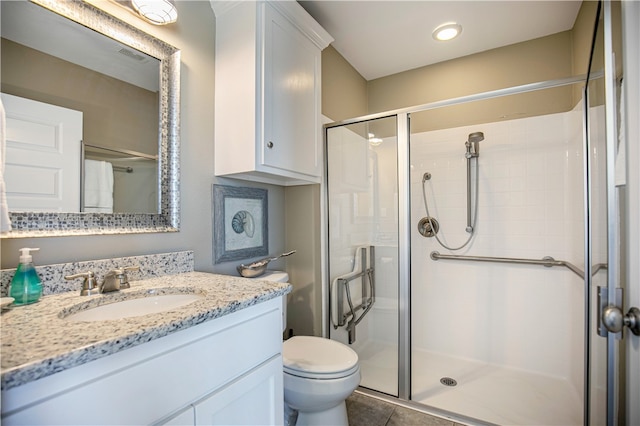 bathroom with toilet, vanity, tile patterned flooring, and a shower with door