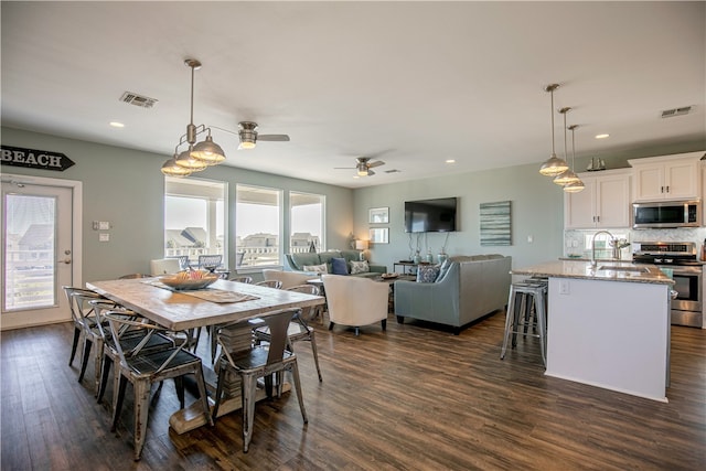 dining area with dark hardwood / wood-style flooring, a wealth of natural light, sink, and ceiling fan