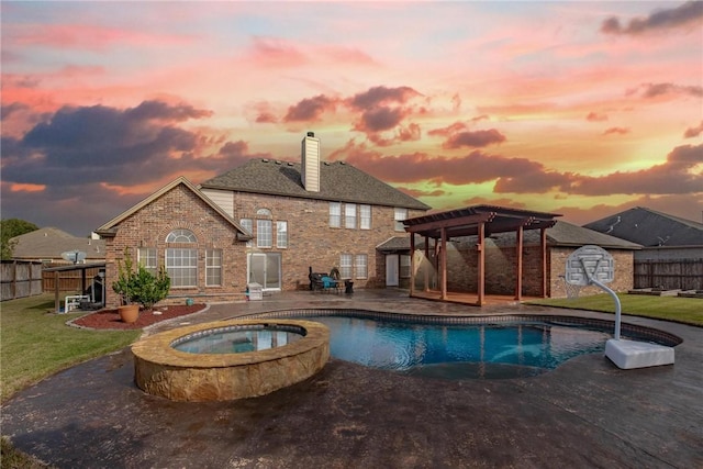 pool at dusk featuring a lawn, an in ground hot tub, and a patio