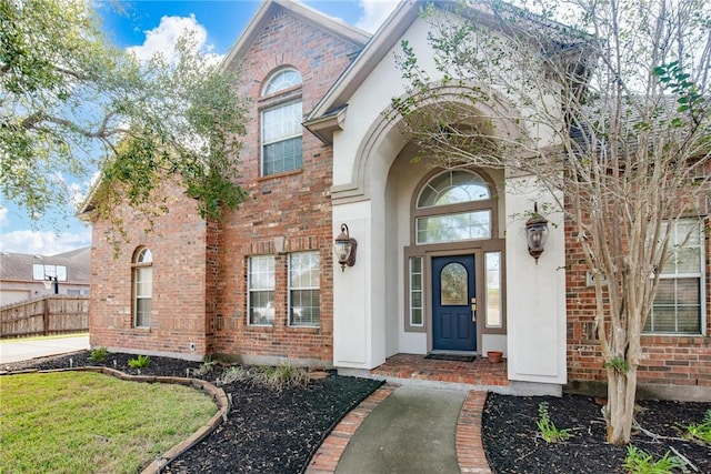 view of exterior entry featuring a lawn