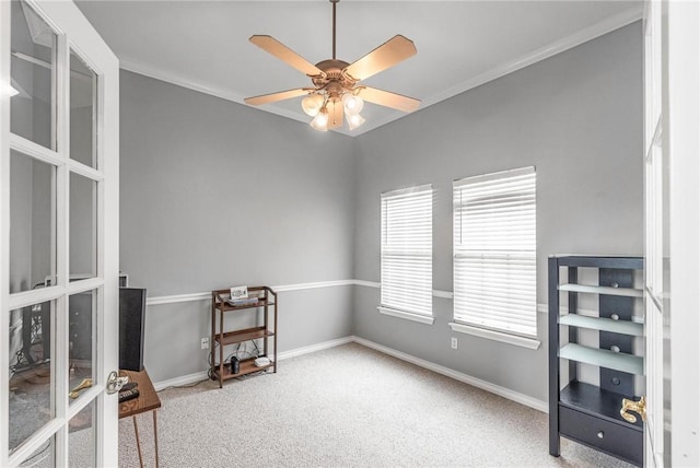 interior space featuring carpet, ceiling fan, and ornamental molding