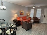 living room featuring wood-type flooring and a chandelier