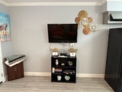 living room featuring light wood-type flooring and crown molding