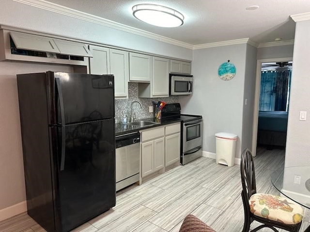 kitchen with stainless steel appliances, decorative backsplash, sink, ornamental molding, and ceiling fan