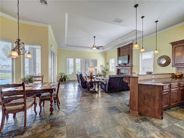 8409 Lago Vista Dr, Corpus Christi, TX 78414 - kitchen featuring stone tile floors, visible vents, crown molding, a raised ceiling, and hanging light fixtures